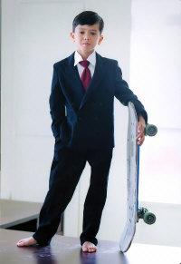 Child in a suit with skateboard