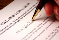 Hand and pen signing a will
